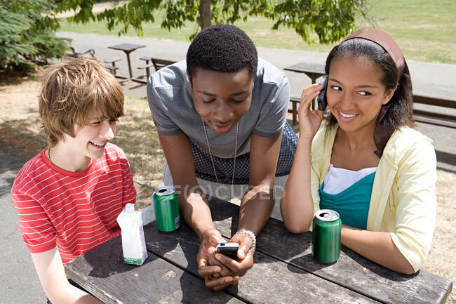 Adolescents avec boissons et téléphones portables — Photo de stock