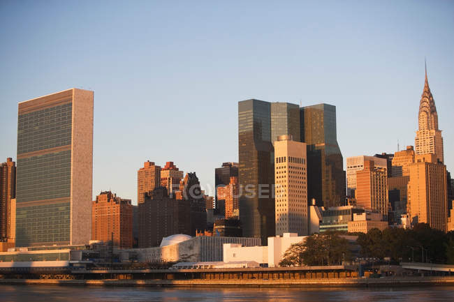 Здания Ист-Ривер и Манхэттен на закате, Нью-Йорк — стоковое фото