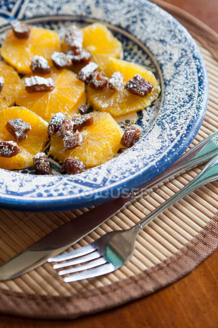 Dessert with orange and dried fruit with sugar powder — Stock Photo