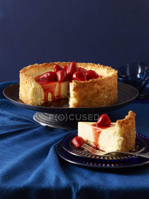 Bodegón de tarta de queso con fresas maceradas y rebanada en el plato - foto de stock