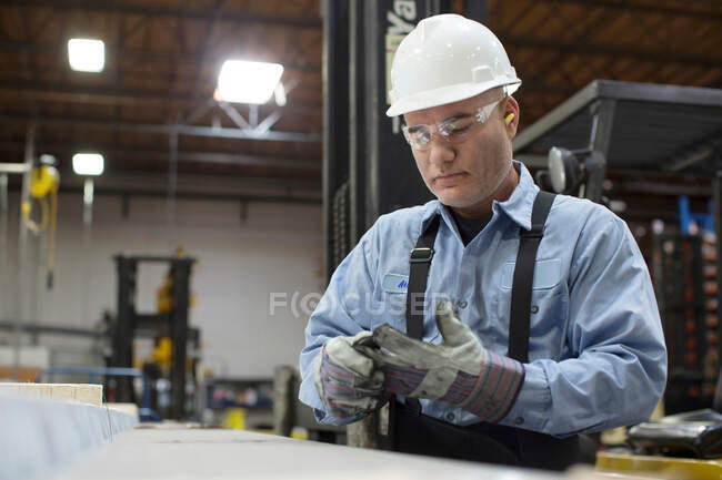 Trabalhador com luvas em fábrica de metal — Fotografia de Stock