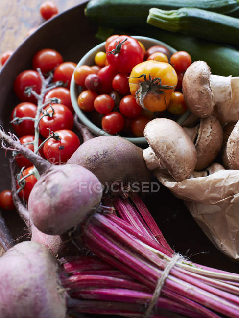Hortalizas frescas y setas con tomates de vid, remolacha y calabacín - foto de stock