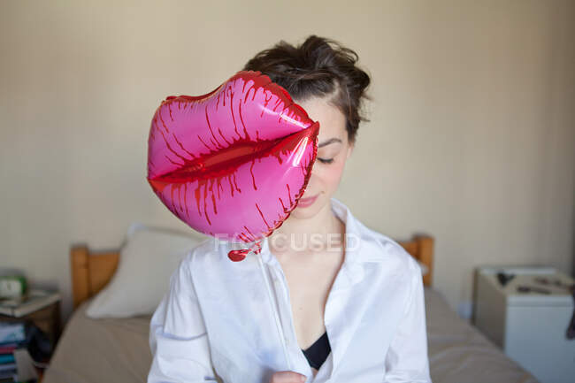 Mujer joven con globo en forma de labios - foto de stock