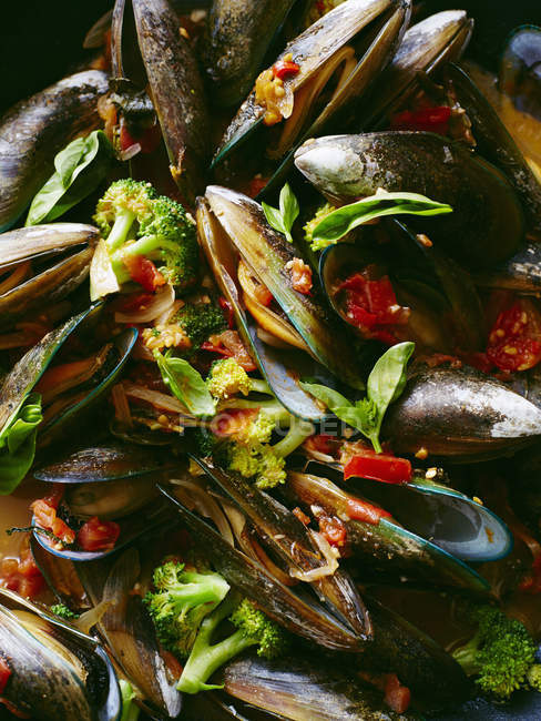 Close up of mussels with broccoli in tomato sauce — Stock Photo