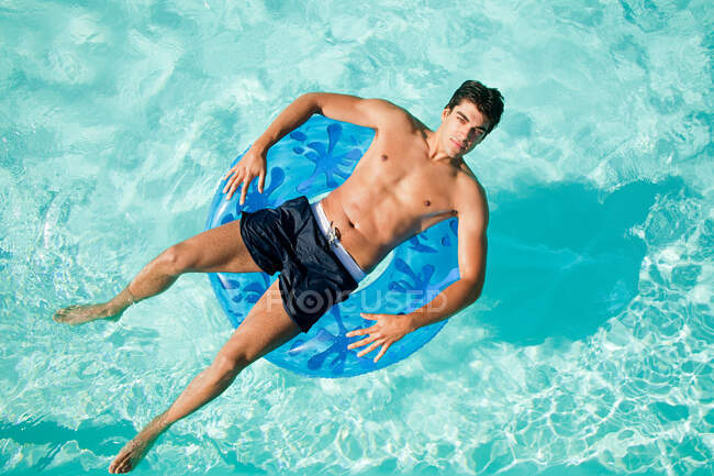 Человек на надувном кольце в бассейне — стоковое фото