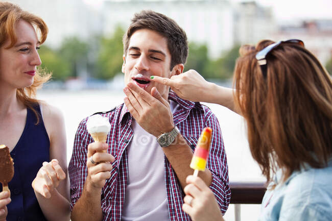 Friends eating icecreams and lollypops — Stock Photo