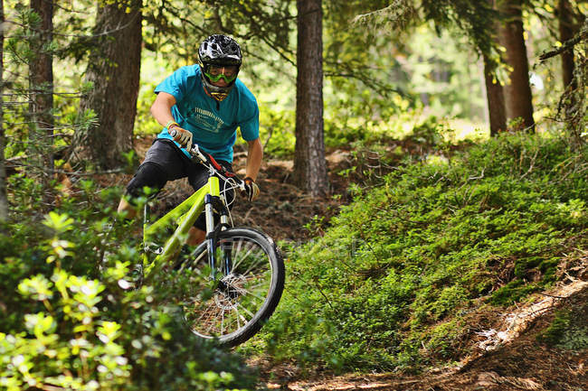 Mountain biker riding off road in forest — Stock Photo