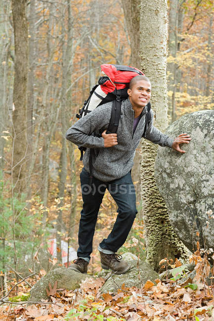 Молодой человек в лесу с рюкзаком — стоковое фото