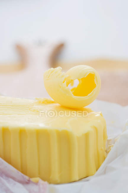 Blocco di burro con fetta, primo piano colpo — Foto stock