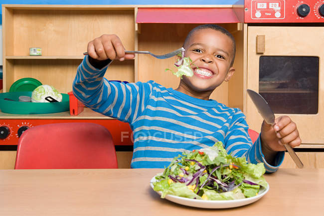Garçon avec une assiette de salade — Photo de stock