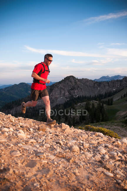 Hombre corriendo por el camino de tierra durante el día - foto de stock