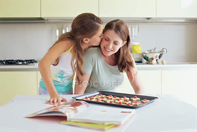 Girl kissing mother on the cheek — Stock Photo