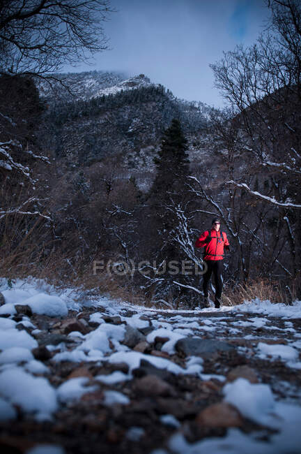Mann läuft durch verschneite Landschaft — Stockfoto
