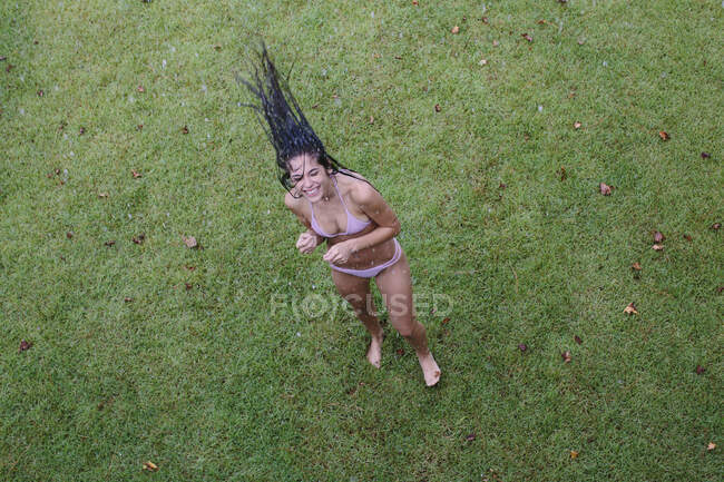 Overhead portrait of young woman throwing back long wet hair on lawn, Santa Rosa Beach, Florida, USA — Stock Photo