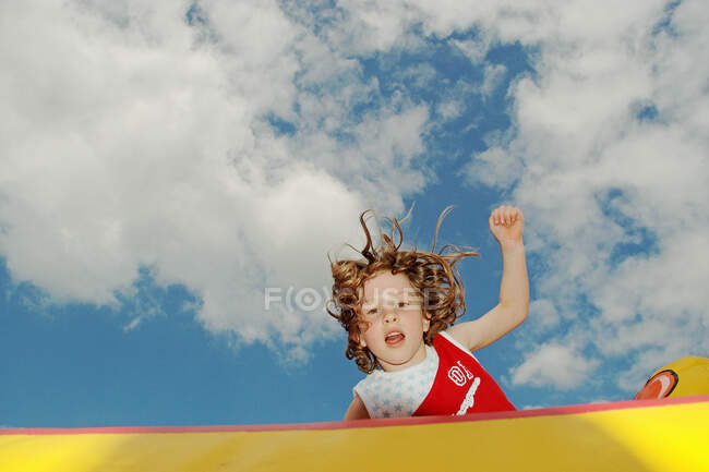 Fille sautant sur château plein d'entrain — Photo de stock