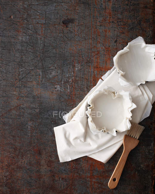 Coquilles de pâtisserie et brosse sur surface rustique — Photo de stock