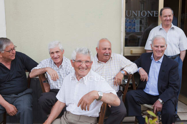 Six old men sitting outside, laughing — Stock Photo