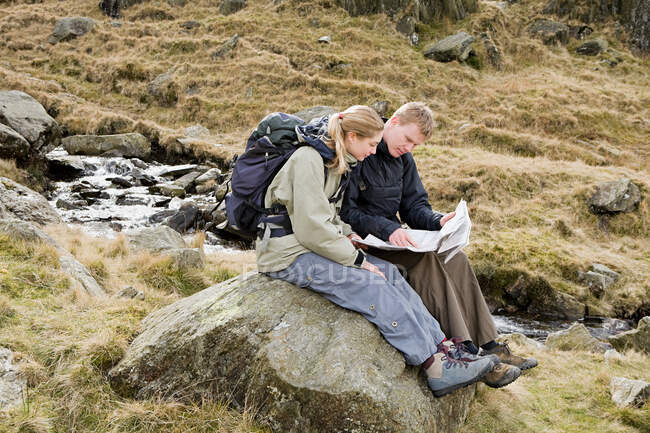 Un couple regardant une carte — Photo de stock