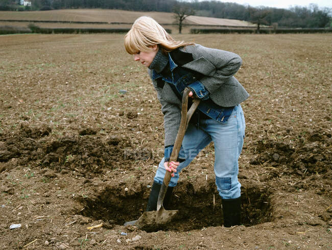 Farmer digging hole in field — Stock Photo