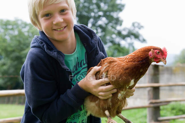 Ortrait of boy holding chicken — Stock Photo