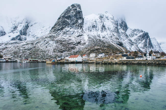 Bâtiments et montagnes enneigées, Reine, Lofoten, Norvège — Photo de stock