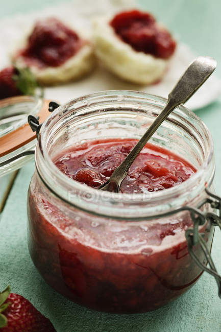Jar of homemade strawberry preserve with teaspoon — Stock Photo