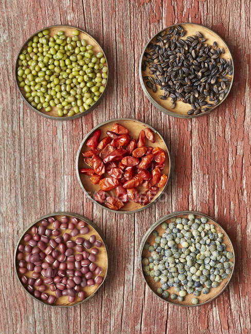 Mung Beans, Black Barley, Pequin Chiles, Adzuki Beans, French Green Lentils portions on wood — Stock Photo