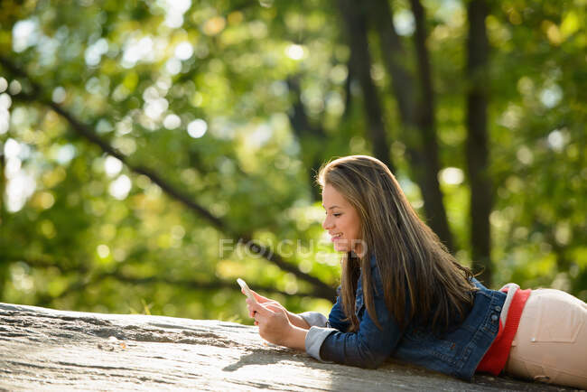 Mulher usando telefone celular no parque — Fotografia de Stock