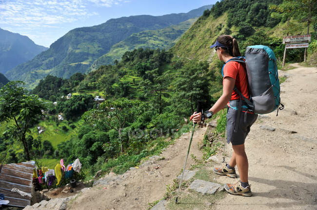 Trekker femenina mirando a la vista, Bahundanda, Nepal - foto de stock