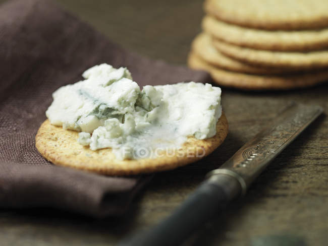 Formaggio blu su cracker con coltello vintage sul tavolo di legno — Foto stock