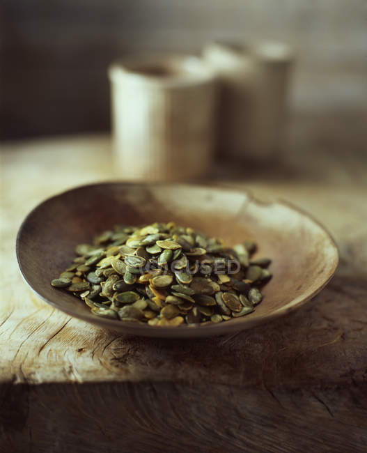 Органические семена тыквы в деревянной чаше — стоковое фото