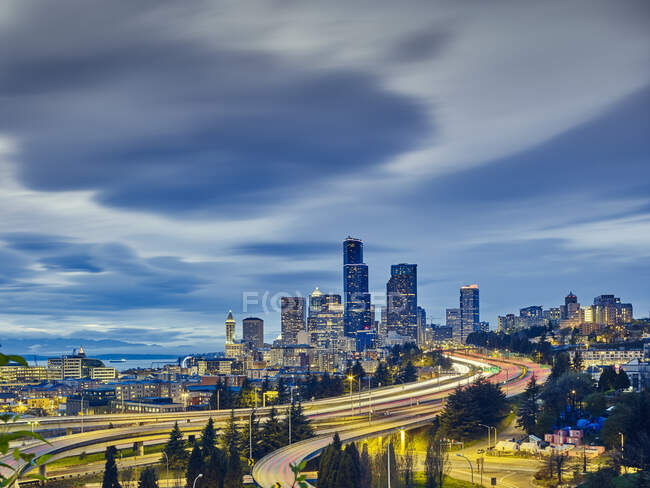 Senderos para semáforos y paisaje urbano al atardecer, Seattle, Washington State, EE.UU. - foto de stock