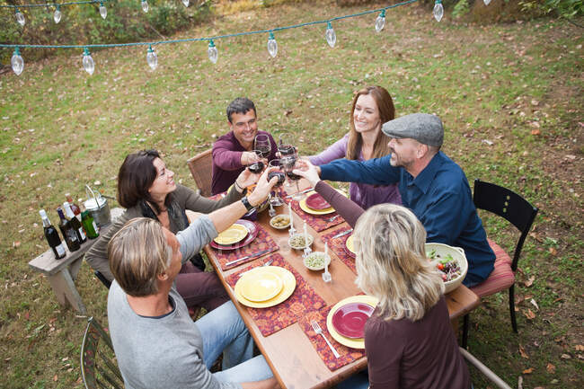 Friends toasting glasses at outdoor dinner — Stock Photo