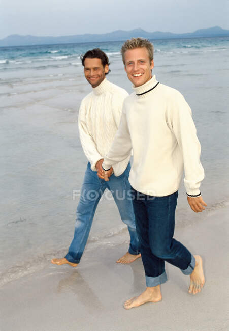 Männer gehen am Strand spazieren — Stockfoto