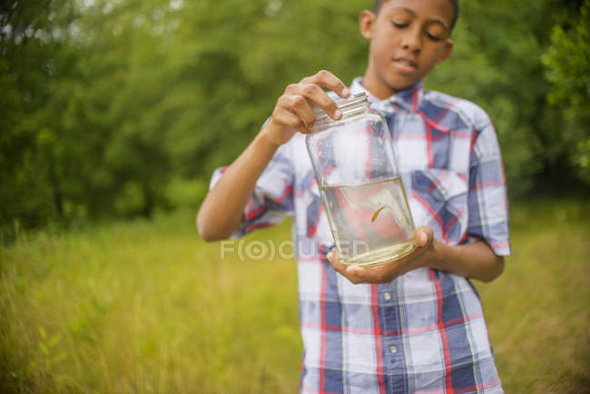 Menino adolescente com peixes em jarra — Fotografia de Stock