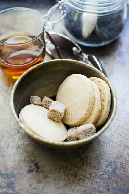 Пісочне печиво в мисці зі склянкою чаю — стокове фото