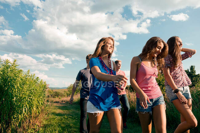 Cinq amis marchant à travers le champ — Photo de stock