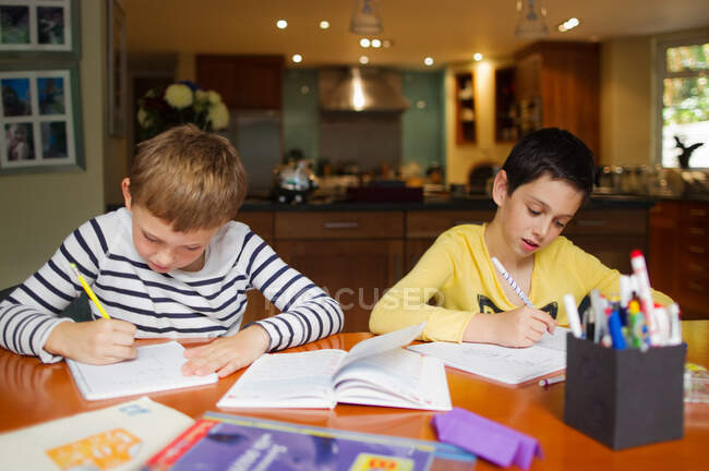 Хлопці роблять домашнє завдання за столом — стокове фото