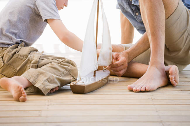 Отец и сын с игрушечной лодкой — стоковое фото