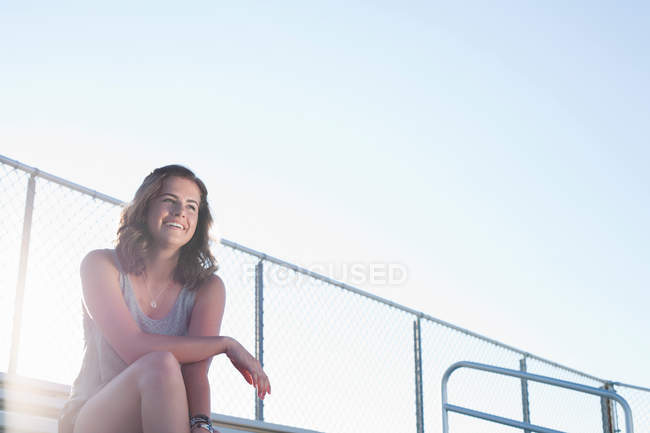 Teenage girl sitting on bleachers, portrait — Stock Photo