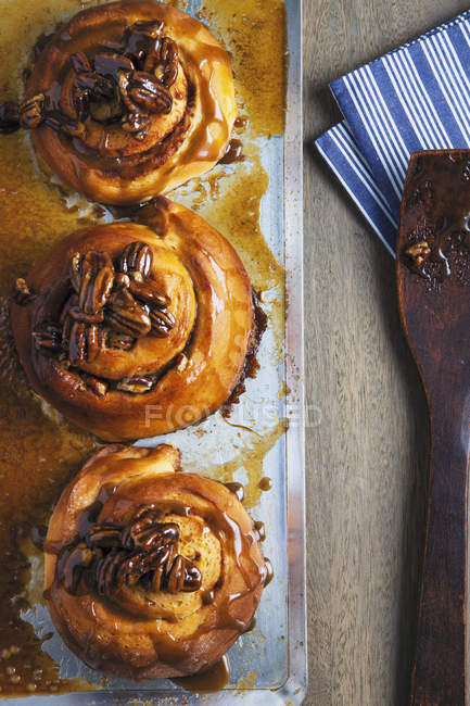 Top view of three sticky buns on baking tray — Stock Photo