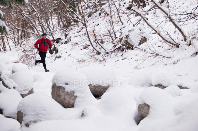 Mann läuft durch verschneite Landschaft — Stockfoto