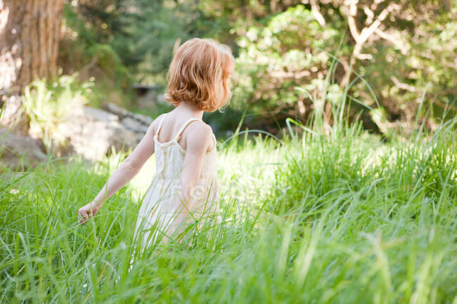 Petite fille dans le champ d'herbe — Photo de stock