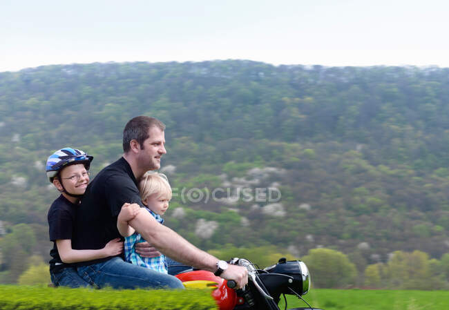 Homme mûr à moto avec fils — Photo de stock
