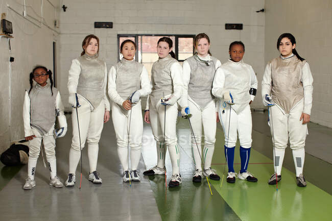 Portrait of female fencers standing together in a row — Stock Photo