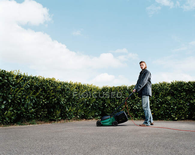 Чоловік косить бетонний газон — стокове фото
