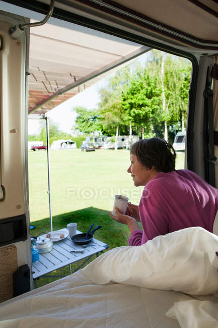 Donna matura che beve bevanda calda in camper — Foto stock