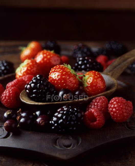 Close up shot of strawberries, raspberries and blackberries on spoon — Stock Photo