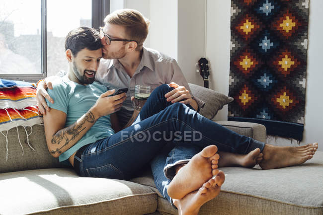 Casal masculino relaxando no sofá juntos — Fotografia de Stock