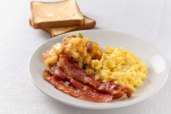Plate of eggs, potatoes and bacon — Stock Photo